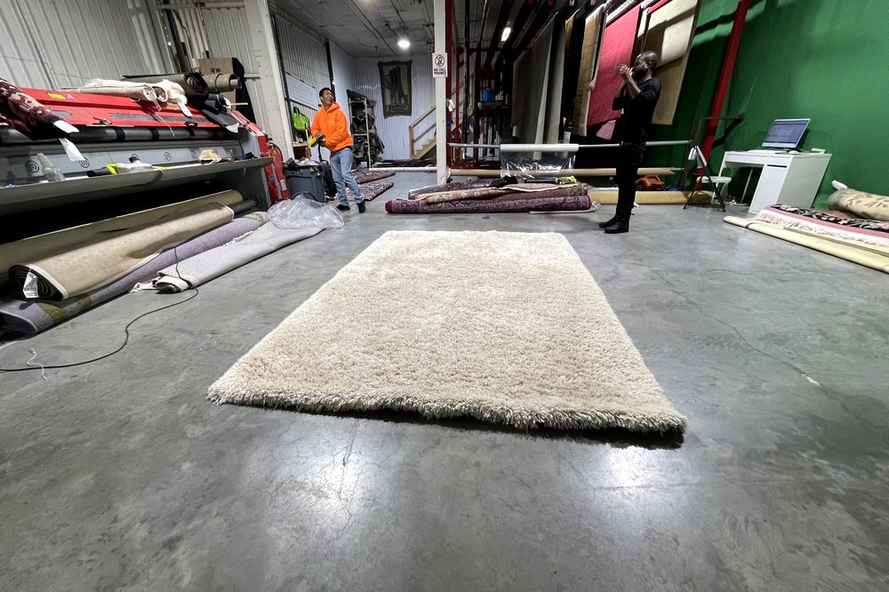 Dr Carpet technician grooming a freshly cleaned wool rug before delivery back to the customer