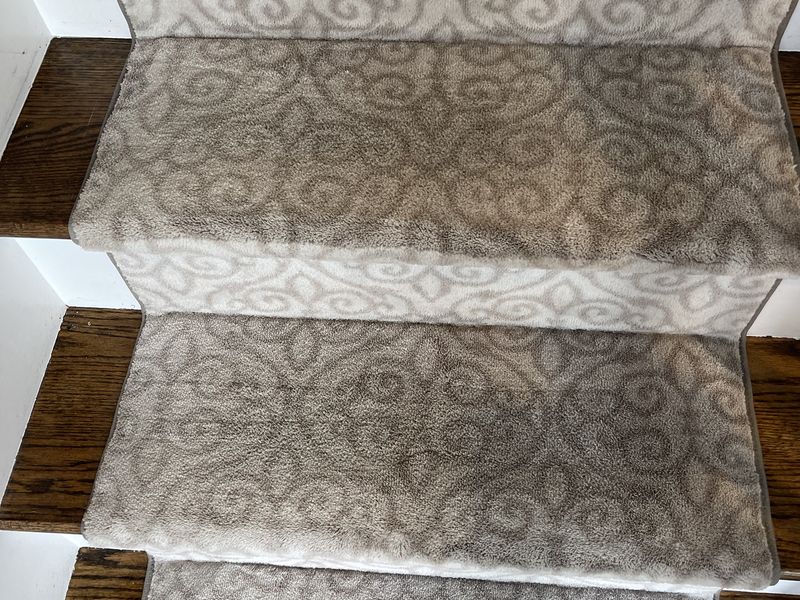 The same scroll-pattern stair runner after cleaning by Dr Carpet